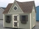 Pine Creek 8x10 Victorian Playhouse with PC Green walls, Navajo White trim and Bronze Z-Style shutters, and Barkwood shingles